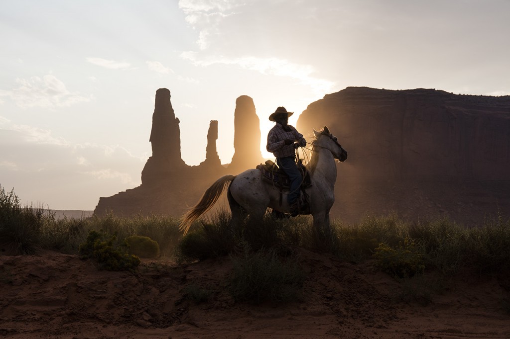 Horse Rider in front of Three Sisters Formation, Monument Valley, Navajo Nation
