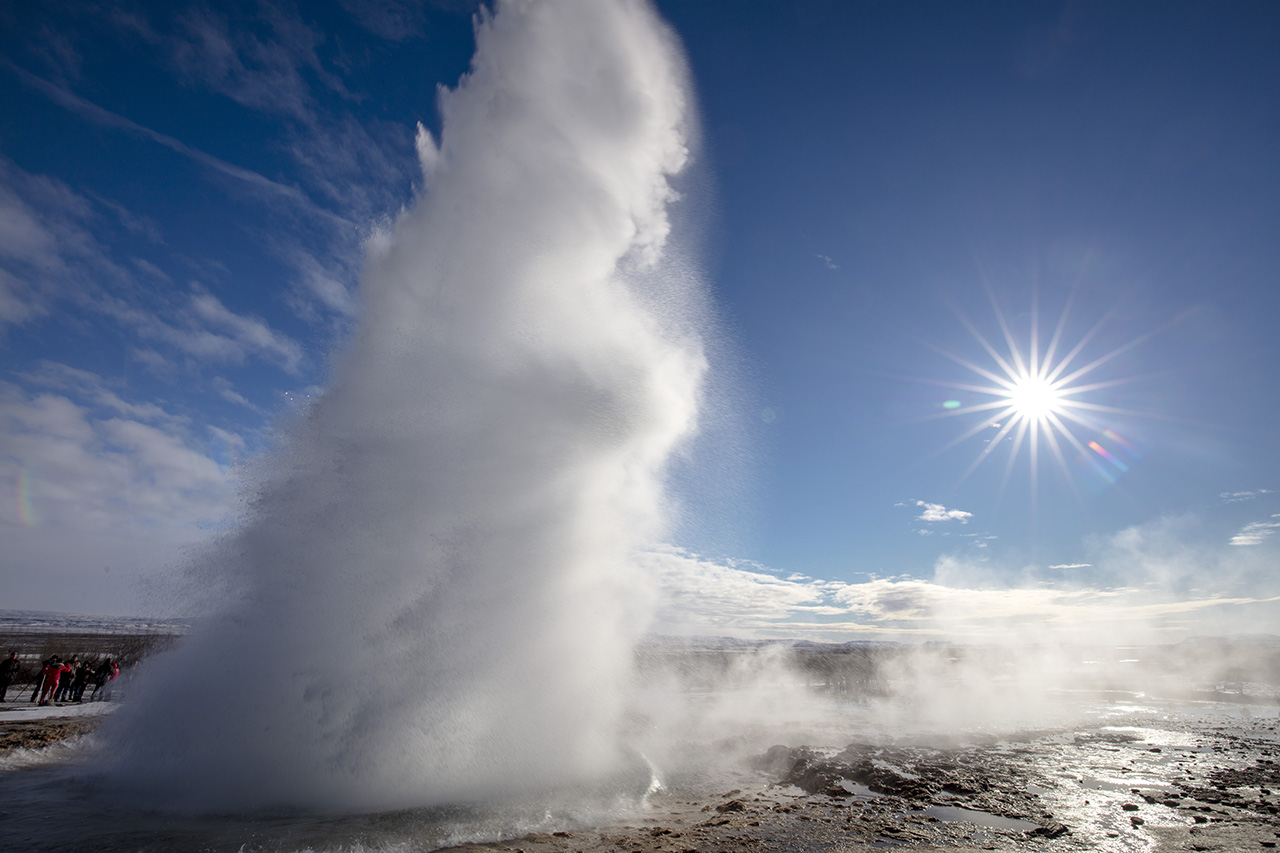 Strokkur erupts with the sun low on the horizon, Geysir, Iceland