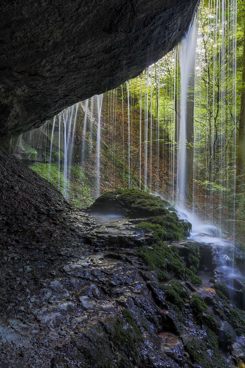 View through water curtain, Upper Hörschbach Waterfall, Murrhardt, Germany